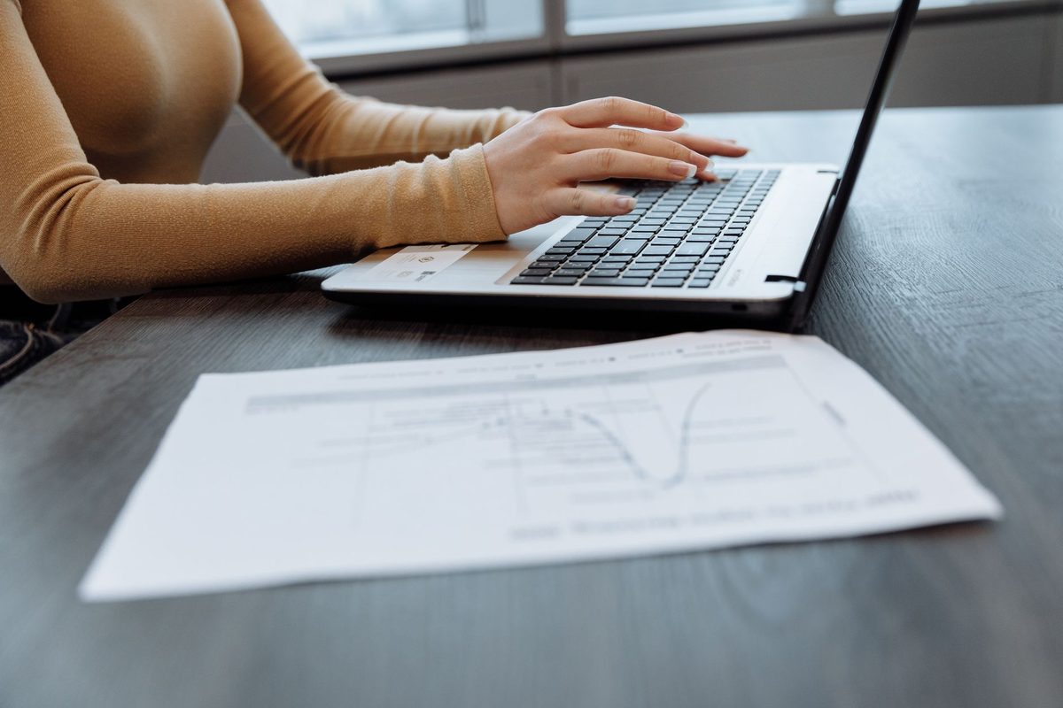 A laptop on a desk displaying a multi-page PDF document