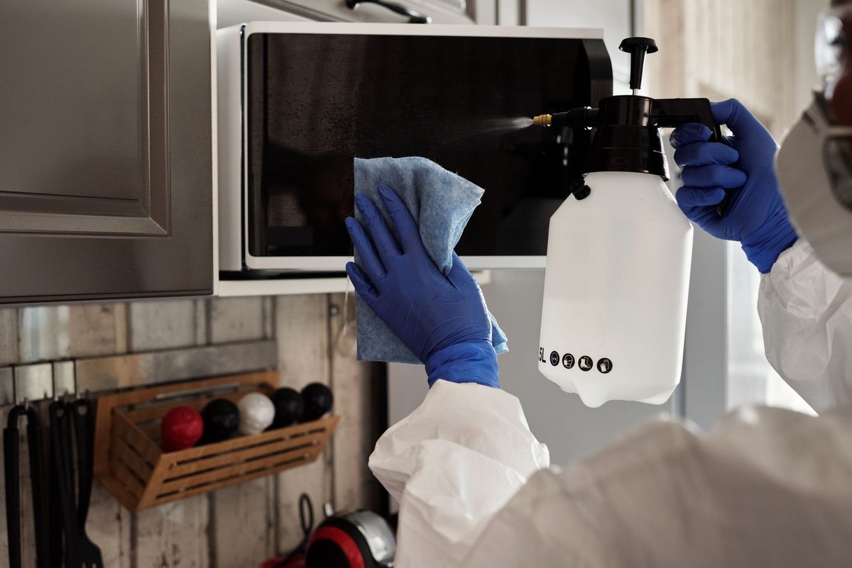 Wiping the inside of a microwave with a cloth, part of the best way to clean a microwave