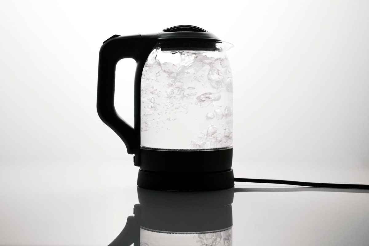 Pouring water from a clean kettle, relevant to how to clean a kettle