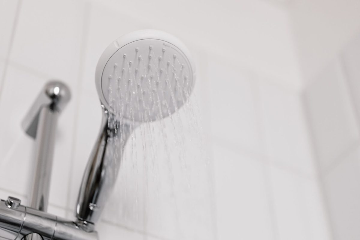 A clean shower head running water, relevant to how to clean a shower head